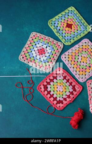 Crochet project in making. Colorful crochet squares close up photo. Hand made top in process. Stock Photo