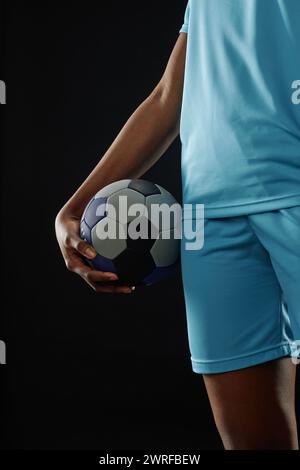 Close up of unrecognizable female football player holding ball and wearing blue uniform copy space Stock Photo