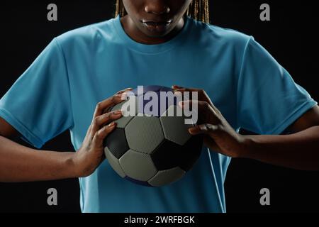 Cropped concept shot of female football player holding ball to chest and looking down copy space Stock Photo