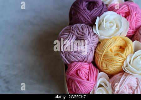 Bouquet made of cotton yarn balls  in a wooden box. Colorful photo of soft pink organic yarn. Hobbies and leisure concept. Stock Photo