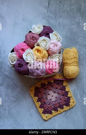 Heart-shaped box with white roses and cotton yarn on a gray background. Cotton yarn texture close up photo. Art and craft concept. Stock Photo