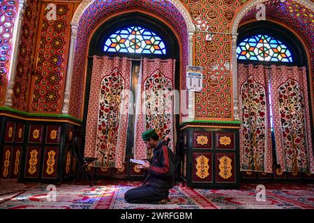 A Kashmiri Muslim recites the Holy Quran inside the shrine of Syed ...