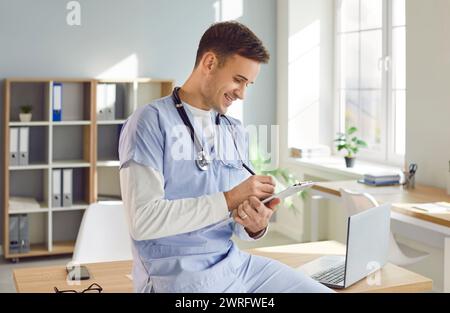 Portrait of a young male doctor in blue medical uniform working in medical office Stock Photo