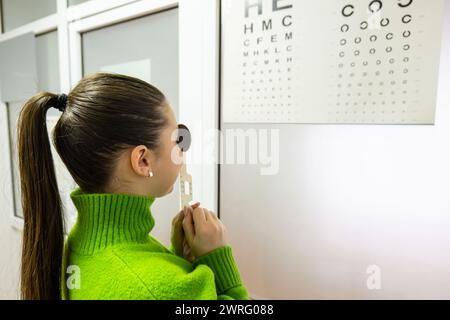 A woman with very beautiful hair surprised while looking with one eye blocked by a special sight object, the girl was looking at the special hieroglyp Stock Photo