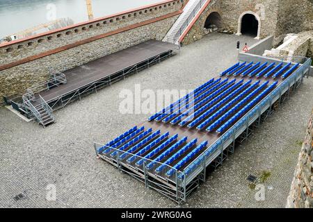 Outdoor concert venue with stage and empty seats rows, mobile metal structure with plastic seats Stock Photo