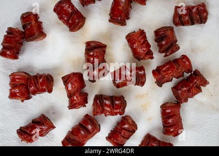 Fried sausage pieces soaking on paper towel tissue , saturated oils health problem concept Stock Photo