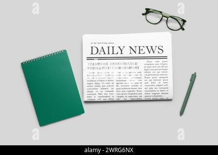 Newspaper with pen and glasses on grey background. Top view Stock Photo