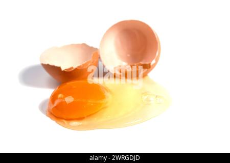 Cracked brown chicken egg against a white background Stock Photo