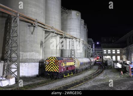 HNRC 08879 passes the silos at Breedon Hope cement works on 18.12.23. Stock Photo