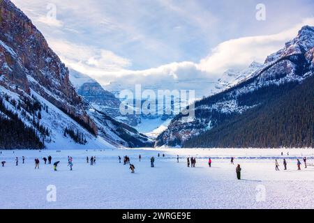Unidentifiable visitors skating on frozen Lake Louise in the winter against the backdrop of the stunning Victoria Glacier. The iconic Lake Louise typi Stock Photo