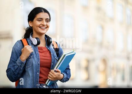 Positive young eastern lady student posing at university campus Stock Photo
