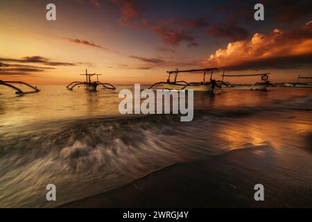 Silhouette of traditional jukung boats anchored on a beach at sunset, Bali, Indonesia Stock Photo