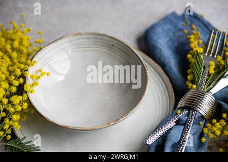 Overhead view of a place setting with yellow mimosa flowers on a table Stock Photo