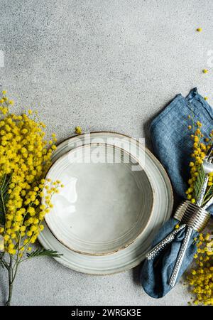 Overhead view of a place setting with yellow mimosa flowers on a table Stock Photo