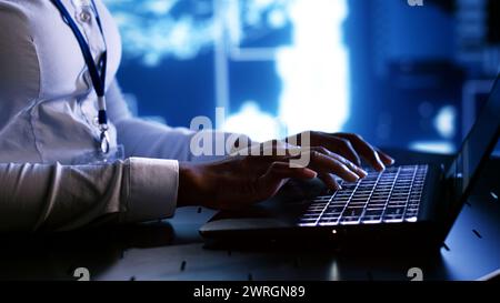 System administrator writing artificial intelligence script code in startup workspace on laptop terminal. Computer operator doing maintenance work in high tech facility updating AI systems Stock Photo