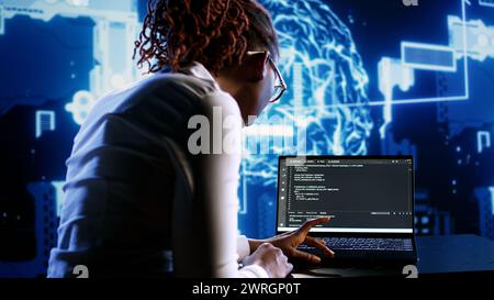 AI cloud computing business executive programming scripts for AI machine learning. Hardworking expert imputing lines of code on laptop for artificial intelligence applications management Stock Photo