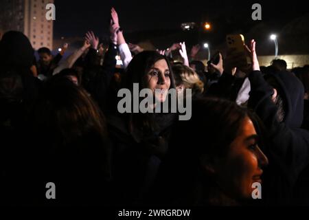 March 12, 2024, Tehran, Iran: Iranian youth dance on the eve of Wednesday's traditional Fire feast, or Chaharshanbeh Soori, held annually on the last Wednesday eve before the Spring holiday of Nowruz, in Tehran. The Iranian New Year (Nowruz) which begins on March 20 coincides with the first day of spring during which locals revive the Zoroastrian celebration of lighting a fire and dancing around the flame. Nowruz, which has been celebrated for at least three thousand years, is the most revered celebration in the Greater Persian world, which includes the countries of Iran, Afghanistan, Azerbaij Stock Photo