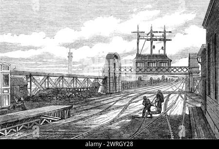 The Charing-Cross Railway: the signal station on the north end of the bridge, [London], 1864. 'The signal station...is remarkable for the ingenious character of its arrangements. By the use of one of Saxby and Farmer's patent signalling instruments, one man is enabled to conduct the whole of the numerous trains in and out of the station without difficulty; whereas, by the old-fashioned plan at least half a dozen men at a time would have been required...Of course the labour cannot now be performed without considerable care; there are, therefore, three signalmen employed at this one station, who Stock Photo