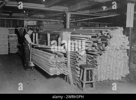 Examining spruce for planes, between c1915 and c1920. A man at an airplane factory is seen looking for imperfections in spruce to be used for the construction of airplanes. Stock Photo