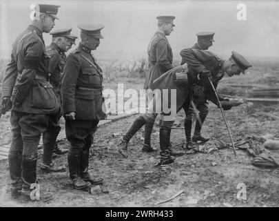 King Albert on Battle Field, 16 May 1917. An aide-de-camp of King Albert I of Belgium picking up a souvenir on the Somme battlefield near Pozieres, France, May 16, 1917. King Albert I and General Hubert Gough, the British Commander of the Fifth Army stand in background. Stock Photo