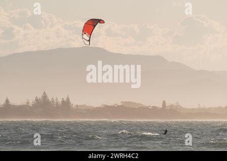 Senior man kitesurfing on a Byron Bay beach during sunset. Australia. Stock Photo