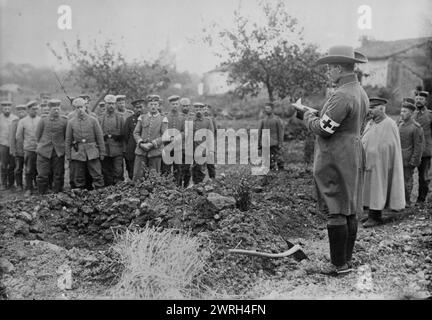 German Field chaplain burying French Officer who died in hospital, 1914. German chaplain standing next to a grave with other men, during World War I. Stock Photo