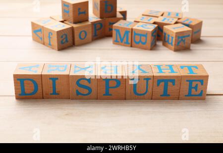 Cubes with word Dispute on light wooden table Stock Photo