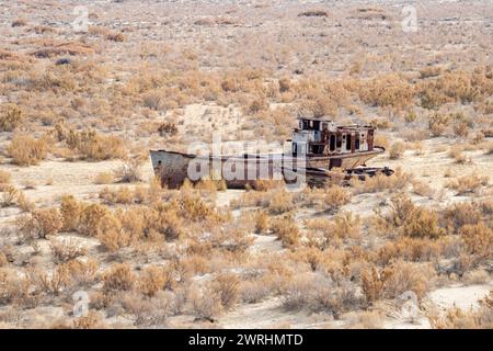 A rusty ship at the bottom of the former Aral Sea. The dried-up sea in an environmental disaster and climate change in Central Asia. the problems of g Stock Photo