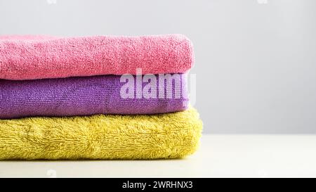 a pile of clean, folded and colored towels on a white background Stock Photo