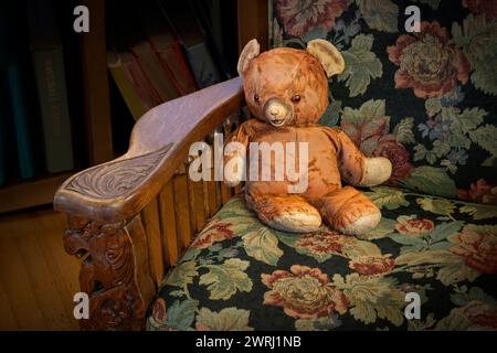Teddy bear sitting on vintage armchair. Stock Photo