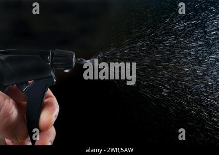 Aerosol spraying with black background Stock Photo - Alamy