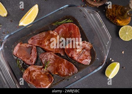 marinated Pieces of Fresh tuna Fish fillet in glass cooking dish on a kitchen table. Stock Photo