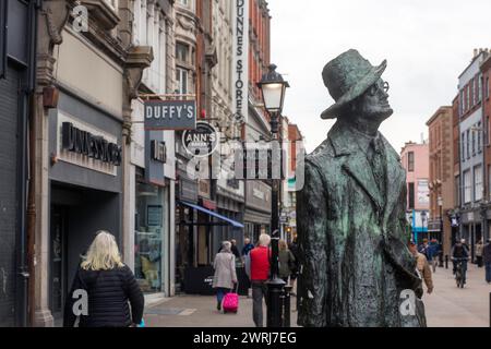 A statue by Marjorie Fitzgibbon (American-Irish sculptor), to James Joyce in central Dublin as ordinary Dubliners go about their business. Dublin Stock Photo