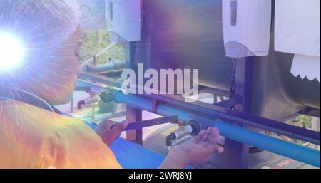 Image of lights and lens flare over african american woman washing hands outdoors at standpipe Stock Photo