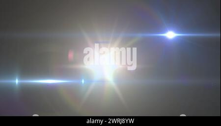 Image of spotlight with lens flare and light beams moving over dark background Stock Photo