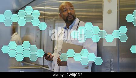 Image of cell structures processing data over african american male doctor using smartphone Stock Photo