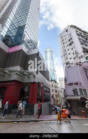 Hong Kong - July 15, 2017: Central District cityscape, vertical street view, wide angle photo with people walking the city under tall skyscrapers Stock Photo