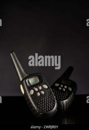 Different angles of black walkie talkie with gray keypad isolated on dark background Stock Photo