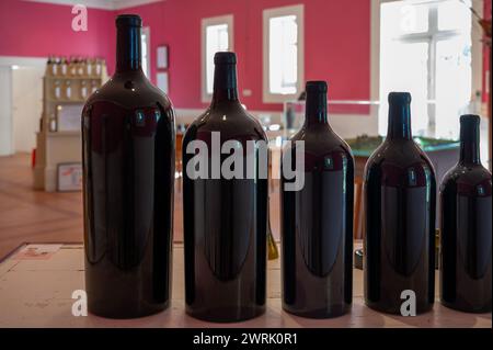 Different sizes of unlabled bottles of red Bordeaux wine in tasting room, wine domain in Haut Medoc, wine tour and degustations, France Stock Photo