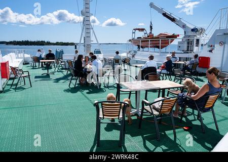 SKARVEN FERRY, FÖGLÖ to ÅLAND, BALTIC SEA ARCHIPELAGO: Passengers enjoy the summer sunshine on board the Baltic Sea Ferry M/S Skarven Summer Crossing to Föglö in the Åland Islands Baltic Sea, Finland. Photo: Rob Watkins. INFO: Föglö is a rural island in the Åland archipelago in Finland. It is known for its rolling hills, forests, and fertile farmland, as well as its traditional wooden architecture and charming villages. Stock Photo