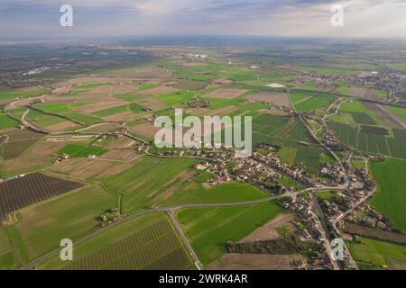 This aerial view captures a vast rural area in the Pianura Padana region, characterized by endless green fields and farmland stretching as far as the Stock Photo