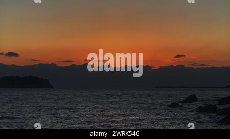 The sun setting over the ocean Stock Photo