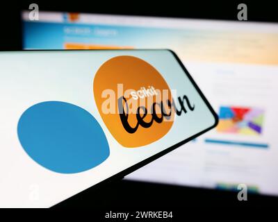 Mobile phone with logo of software machine learning library scikit-learn in front of website. Focus on center-left of phone display. Stock Photo