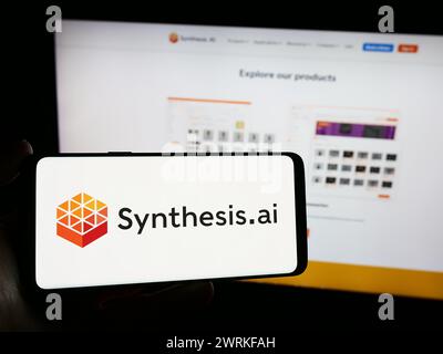 Person holding mobile phone with logo of American artificial intelligence company Synthesis AI Inc. in front of web page. Focus on phone display. Stock Photo