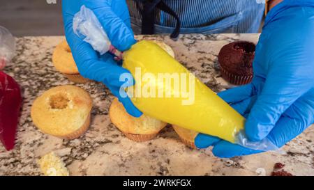 Filling Vanilla, Chocolate Cupcakes with Lemon, Raspberry Stock Photo