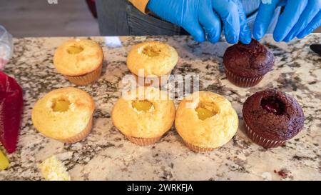 Filling Vanilla, Chocolate Cupcakes with Lemon, Raspberry Stock Photo