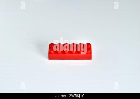 The detail of the children's designer made of red plastic lies on a white background. Stock Photo
