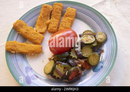 fish sticks with tomato and sautéed courgettes Stock Photo