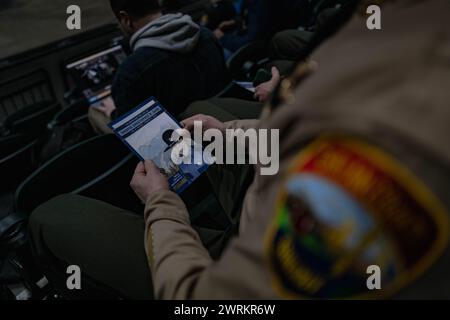 A trooper holds a poster of Washington State Patrol trooper Chris Gadd during a poignant memorial at Angel of the Winds Arena in Everett, Washington. Public memorial held at the Angel of the Winds Arena, hundreds of law enforcement officers, family members, friends, and community members paid their respects to a man who dedicated his life to serving others. Chris Gadd, at only 27 years old, tragically lost his life on March 2 in a devastating collision on southbound I-5 near Marysville. His untimely passing sent shockwaves through the community, leaving behind his wife and 2-year-old daughter. Stock Photo