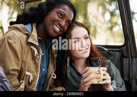 Happy women, coffee or relax on road trip in nature or travel adventure for leisure in countryside. Ladies, drinking and tea in suv on summer holiday Stock Photo